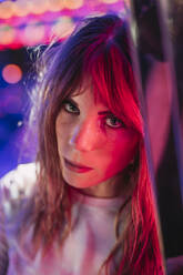 Portrait of a young woman on a funfair at night - LJF00879