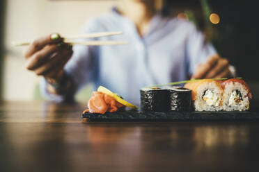 Nahaufnahme einer Frau, die in einem Restaurant Sushi isst - OYF00056