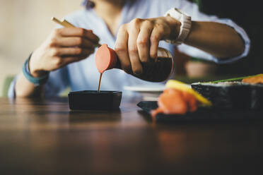 Close-up of a woman eating sushi in a restaurant - OYF00058