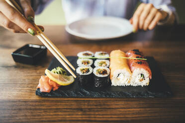 Nahaufnahme einer Frau, die in einem Restaurant Sushi isst - OYF00059