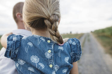 Close-up of father carrying daughter outdoors - KMKF01048