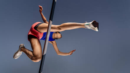 Worm's eye view of female runner crossing hurdle - STSF02208