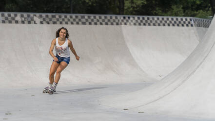 Junge Frau beim Inline-Skaten im Skatepark - STSF02215