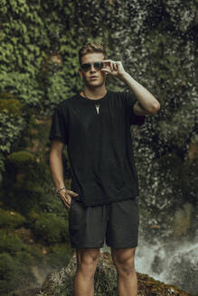 Porträt eines coolen jungen Mannes an einem Wasserfall - ACPF00631