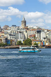 Fähre auf dem Meer mit Gebäuden im Hintergrund gegen den Himmel in Istanbul, Türkei - KNTF03335