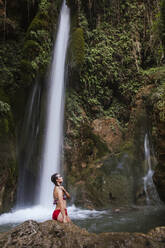 Junge Frau posiert an einem Wasserfall - LJF00907