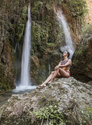 Young woman posing at a waterfall - LJF00908