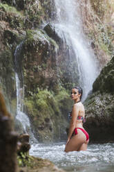 Junge Frau posiert an einem Wasserfall - LJF00912