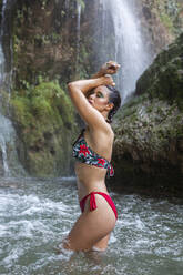 Junge Frau posiert im Wasserfall mit verbranntem Körper - LJF00913