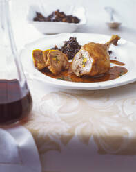 Nahaufnahme einer gefüllten Gänsekeule mit Beluga-Linsen, serviert in einem Teller auf dem Tisch - PPXF00276