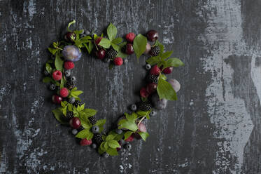 Directly above shot of various fruits with leaves arranged in heart shape on table - ASF06495