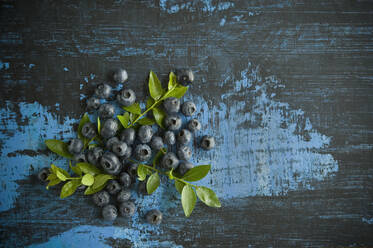 Directly above shot of blueberries with leaves on table - ASF06499