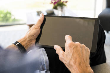 Close-up of senior man using tablet at home - SBOF01995