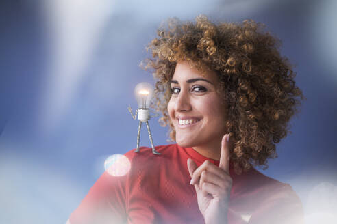 Portrait of smart woman with lightbulb on her shoulder - KSHSF00006