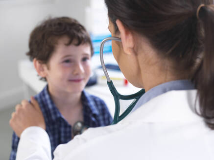 Ärztin untersucht einen Jungen in einer Klinik - ABRF00580