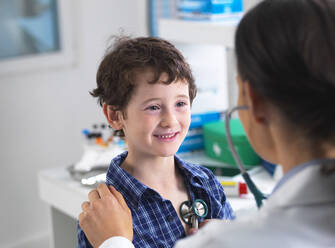 Ärztin untersucht einen Jungen in einer Klinik - ABRF00581