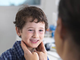 Ärztin untersucht einen Jungen in einer Klinik - ABRF00582