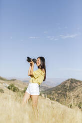 Junge Frau beim Fotografieren in abgelegener Landschaft, Granada, Spanien - LJF00949