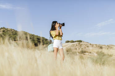 Junge Frau beim Fotografieren in abgelegener Landschaft, Granada, Spanien - LJF00952