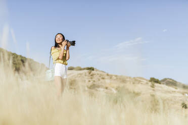 Junge Frau beim Fotografieren in abgelegener Landschaft, Granada, Spanien - LJF00953