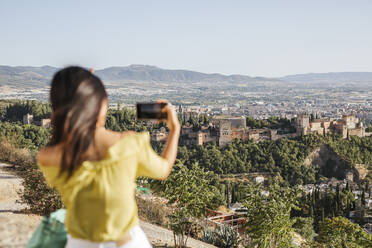 Junge Frau macht ein Handyfoto in der Alhambra, Granada, Spanien - LJF00960