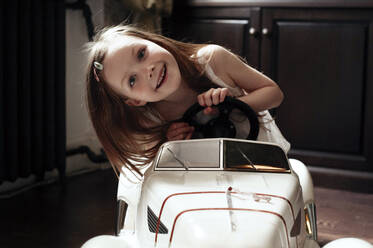 Niedliches kleines Mädchen fährt ihr Spielzeugauto - EYAF00438