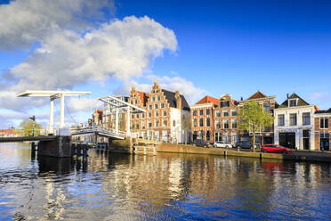 Blauer Himmel und Wolken auf typischen Häusern, die sich in der Gracht des Flusses Spaarne spiegeln, Haarlem, Nordholland, Die Niederlande, Europa - RHPLF07798