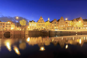 Dämmerung Lichter auf typischen Häusern und Brücke reflektiert in einem Kanal des Flusses Spaarne, Haarlem, Nord-Holland, Niederlande, Europa - RHPLF07800