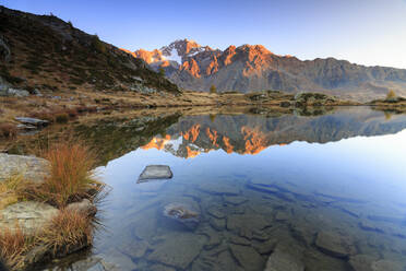 Die felsigen Gipfel des Monte Disgrazia spiegeln sich im Zana-See bei Sonnenaufgang, Malenco-Tal, Valtellina, Lombardei, Italien, Europa - RHPLF07806