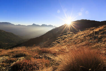 Sonnenstrahlen auf einer Alm mit dem Gipfel des Scalino im Hintergrund, Val Torreggio, Malenco Tal, Valtellina, Lombardei, Italien, Europa - RHPLF07808