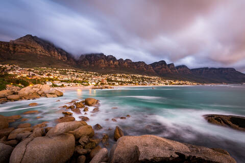 Langzeitbelichtung bei Sonnenuntergang in Camps Bay mit Wolken über dem Tafelberg und den Zwölf Aposteln, Kapstadt, Südafrika, Afrika, lizenzfreies Stockfoto