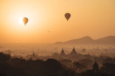 Blick auf Tempel und Heißluftballons bei Sonnenaufgang, Bagan (Pagan), Region Mandalay, Myanmar (Burma), Asien - RHPLF07917