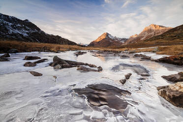 Sonnenuntergang umrahmt den mit Eis bedeckten Alpenbach am Berninapass, Kanton Graubünden, Engadin, Schweiz, Europa - RHPLF07967