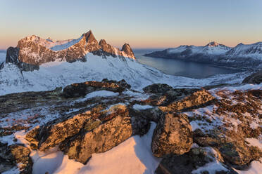 Blick auf das Dorf Husoy und das eisige Meer entlang des Oyfjorden vom Gipfel Hesten in der Morgendämmerung, Lenvik, Senja, Troms, Norwegen, Skandinavien, Europa - RHPLF07969