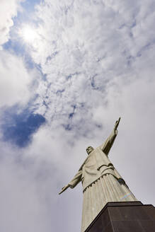 Niedriger Winkel der ikonischen Christus-Erlöser-Statue an einem bewölkten Tag mit Sonne, die durch die Wolken scheint, Rio de Janeiro, Brasilien, Südamerika - RHPLF08023