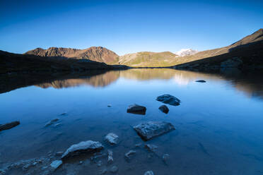 Die felsigen Gipfel spiegeln sich im Umbrail-See bei Sonnenuntergang, Stilfserjoch, Valtellina, Lombardei, Italien, Europa - RHPLF08054