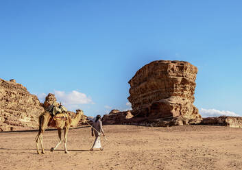 Bedouin walking with his camel, Wadi Rum, Aqaba Governorate, Jordan, Middle East - RHPLF08418