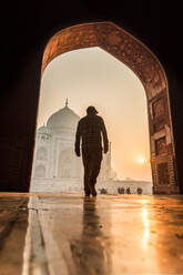 Die Sonne geht hinter dem Taj Mahal auf, ein Mann geht hinein, UNESCO-Weltkulturerbe, Agra, Uttar Pradesh, Indien, Asien - RHPLF08510