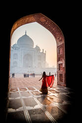 Eine Dame wirbelt, während die Sonne hinter dem Taj Mahal aufgeht, UNESCO-Weltkulturerbe, Agra, Uttar Pradesh, Indien, Asien - RHPLF08511