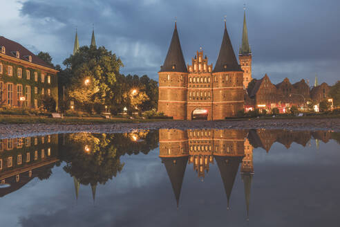 Holstentor an der Trave vor bewölktem Himmel in der Abenddämmerung, Lübeck, Deutschland - KEBF01321