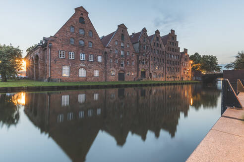 Salzspeicher, der sich in der Trave gegen den Himmel in der Abenddämmerung spiegelt, Lübeck, Deutschland - KEBF01330