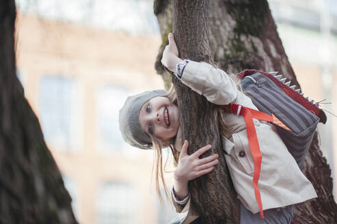 Porträt eines glücklichen Mädchens in einem Baum - EYAF00447