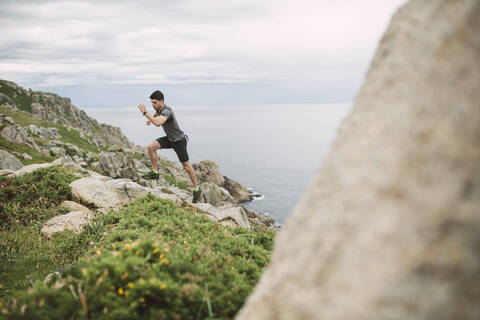 Trailrunner in Küstenlandschaft, Ferrol, Spanien, lizenzfreies Stockfoto