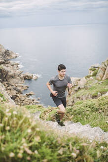 Trailrunner auf Treppe in Küstenlandschaft, Ferrol, Spanien - RAEF02288