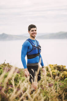 Porträt eines lächelnden Trailrunners in den Bergen, Ferrol, Spanien - RAEF02302