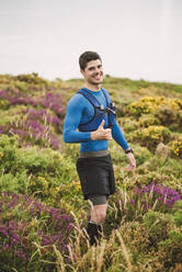 Porträt eines lächelnden Trailrunners in der Natur, Ferrol, Spanien - RAEF02303