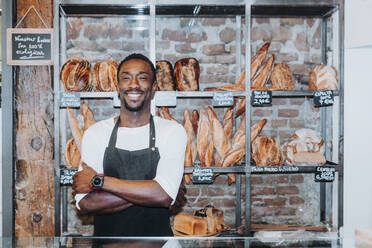 Lächelnder Mann bei der Arbeit in einer Bäckerei - JCMF00148