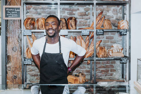Lächelnder Mann bei der Arbeit in einer Bäckerei - JCMF00149