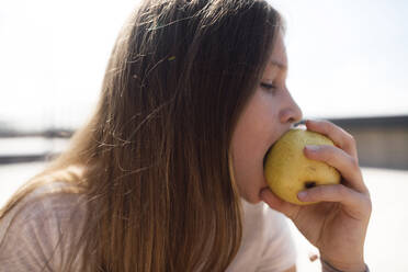 Mädchen isst einen Apfel im Freien - EYAF00451