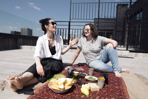 Woman with below-elbow amputation with her friend having a healthy meal on the roof stock photo